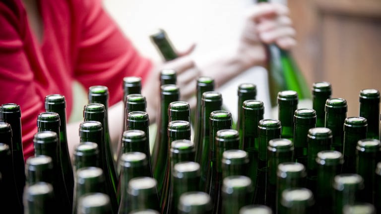 Weinflaschen Flaschen aus Glas werden von einer Mitarbeiterin des Weinguts etikettiert. (Foto: dpa Bildfunk, (c) dpa)