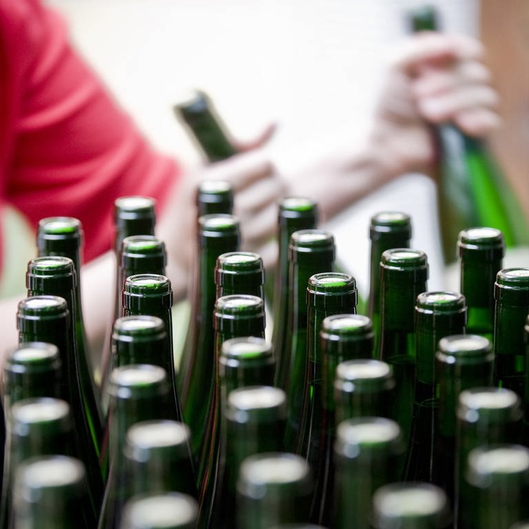 Weinflaschen Flaschen aus Glas werden von einer Mitarbeiterin des Weinguts etikettiert. (Foto: dpa Bildfunk, (c) dpa)