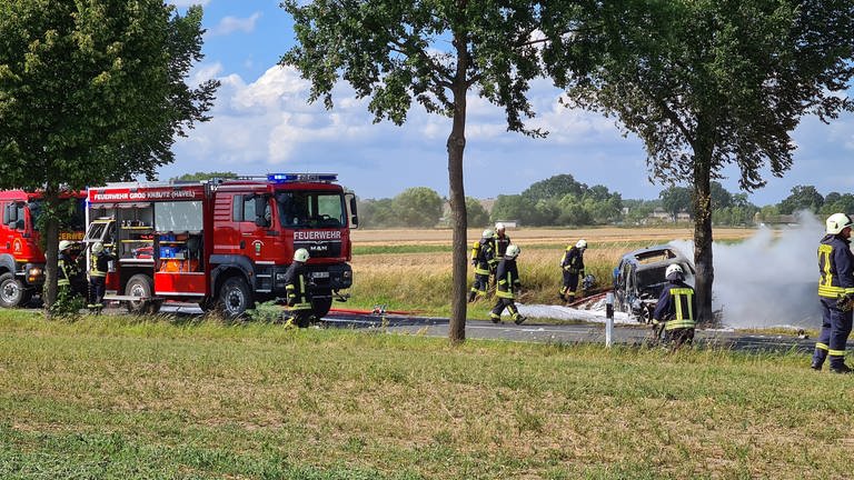 Feuerwehrleute löschen das Unfallwrack eines E-Autos.  (Foto: dpa Bildfunk, Picture Alliance)