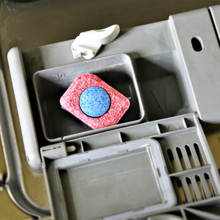 Ein Spülmaschinentab liegt im Fach einer Spülmaschine (Foto: Colourbox)