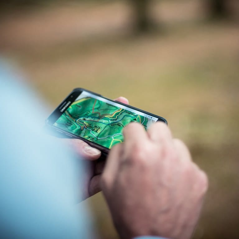 Person betrachtet Wanderkarte auf dem Smartphone. Wander-Apps wie Komoot und Outdoor Active im Test. (Foto: Unplash / Linda Söndergaard)