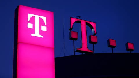Das Logo der Deutschen Telekom leuchtet auf dem Dach der Unternehmenszentrale.  (Foto: dpa Bildfunk, picture alliance/dpa | Oliver Berg)