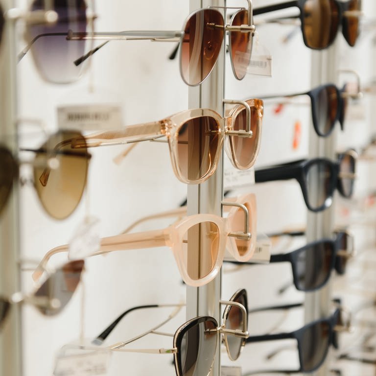 Sonnenbrillen auf einen Ständer. Welche Sonnenbrillen sind gut? Was taugen Sonnenbrillen vom Drogeriemarkt? Welche Sonnenbrillen schützen am besten? Sonnenbrillen im Test. (Foto: Adobe Stock, Adobe Stock/Serhii)