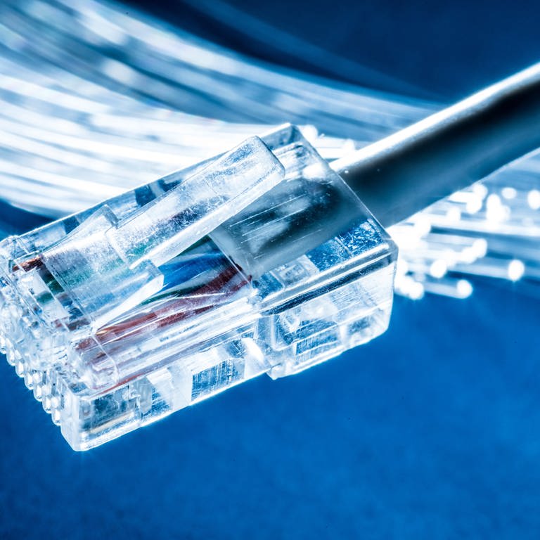 Glasfaserm, davor ein LAN-Kabel. Glasfaservertrag an der Haustür: Verbraucher beschweren sich über Vertriebsmethoden. (Foto: Adobe Stock, Adobe Stock/ volff)