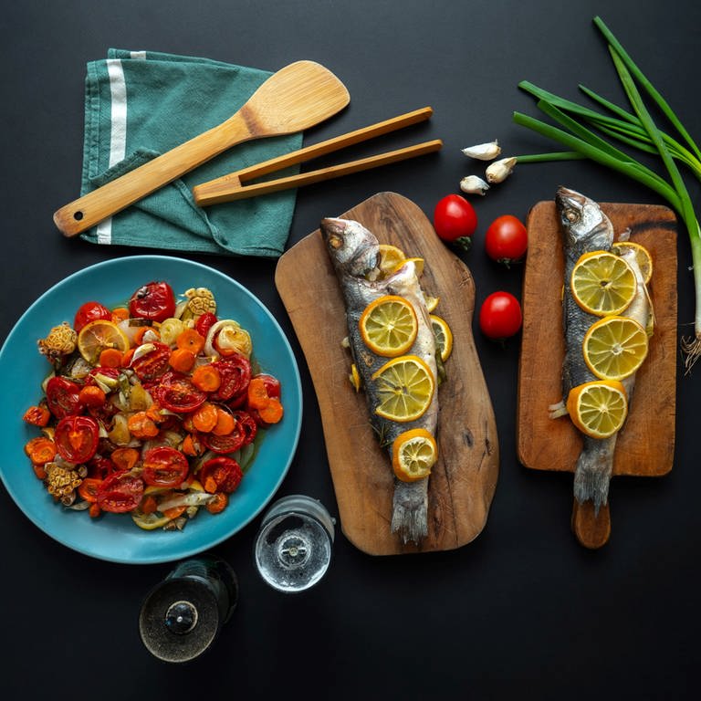 Fisch und Gemüse auf einem Tisch, beides gehört zur Mittelmeerdiät. Bei der Mittelmeer-Diät steht Olivenöl löffelweise im Ernährungsplan. Das ist lecker und sehr gesund. So integriert man Gemüse, Fisch und Co. lecker in den Alltag. (Foto: Unsplash/Dan Cristian Padure)
