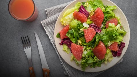 Auf einem Teller ist ein Salat mit Grapefruit und Radicchio angerichtet. Beides enthält Bitterstoffe. Löwenzahn bereichert jeden Salat. (Foto: Colourbox, COLOURBOX31154849)