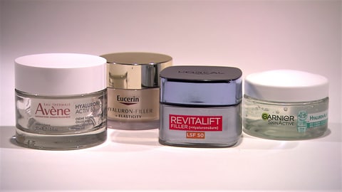 Vier verschiedene Hyaluron-Cremes von Avène, Eucerin, L'Oréal und Garnier stehen nebeneinander aufgereiht hinter einem weißen Hintergrund. (Foto: SWR)