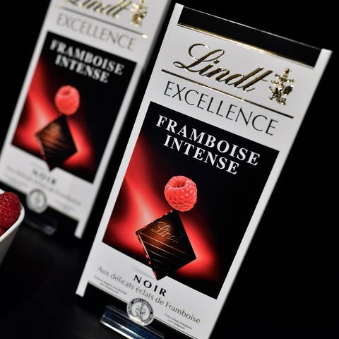 Auf einem schwarzen Hintergrund sind zwei Tafeln Lindt Excellence Schokolade in der Geschmacksrichtung Himbeere zu sehen. (Foto: dpa Bildfunk, Picture Alliance)