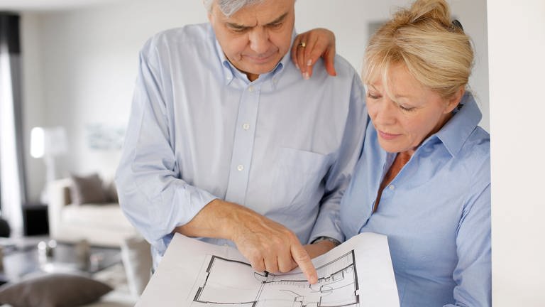 Mann und Frau betrachten den Grundriss einer Wohnung. Grundsteuer. (Foto: Colourbox)