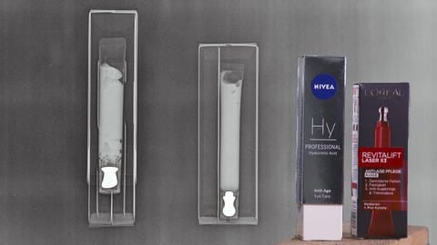 Kosmetik-Packungen von Nivea und L'Oréal unterm Röntgengerät