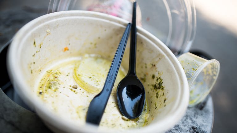 Benutztes Plastikgeschirr liegt auf einem Mülleimer. Nach dem Essen landen die Teller im Müll. Seit 3. Juli 2021 ist Einwegplastik in der EU verboten. (Foto: dpa Bildfunk, Picture Alliance)