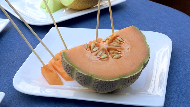 Aufgeschnittene Cantalup-Melone mit orangenem Fruchtfleisch und gerippter Schale. Alles Wissenswerte zu Honigmelonen, Zuckermelonen, Wassermelonen, Galia-, Netzmelone und Cantalup (Foto: SWR)