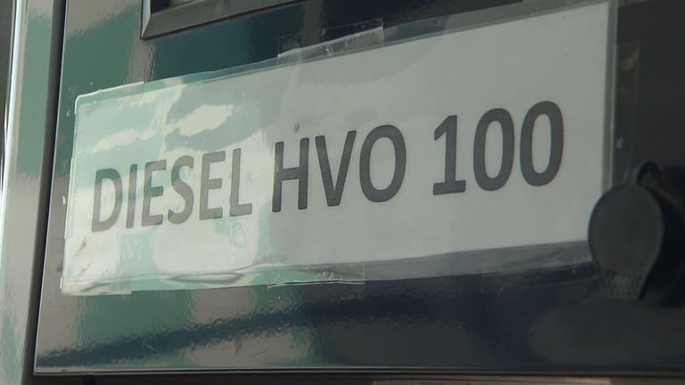 An einer Zapfsäule steht ein Schild mit HVO 100 Diesel.