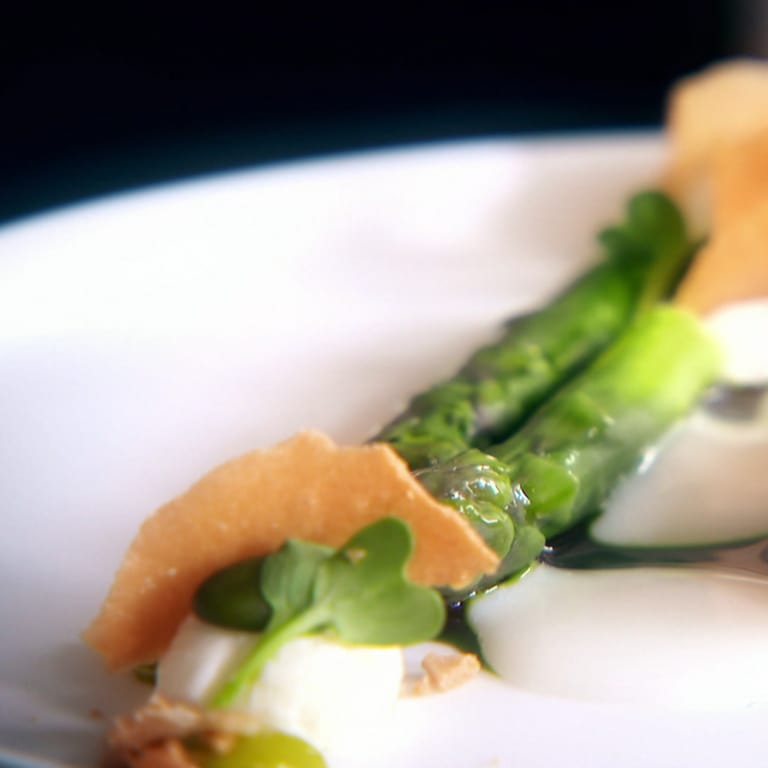 Ein Gericht mit Spargel, angerichtet auf einem Teller: Grüner Spargel mit Bärlauch, fermentiertem Spargelsud, Parmesanmousse und gebeiztem Lachs. (Foto: SWR)
