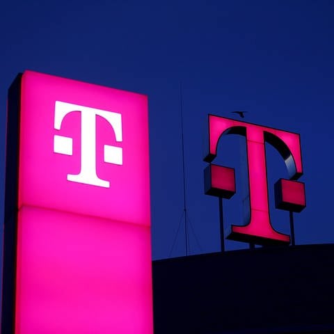 Das Logo der Deutschen Telekom leuchtet auf dem Dach der Unternehmenszentrale.  (Foto: dpa Bildfunk, picture alliance/dpa | Oliver Berg)