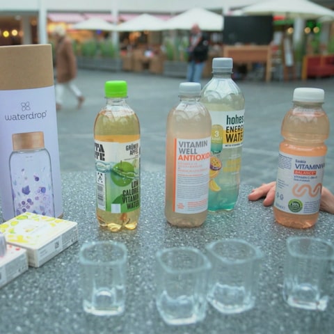 Auf einem Stehtisch stehen nebeneinander verschiedene sogenannte Vitaminwasser verschiedener Marken. Das Wasser ist mit Vitaminen angereichert. (Foto: SWR)