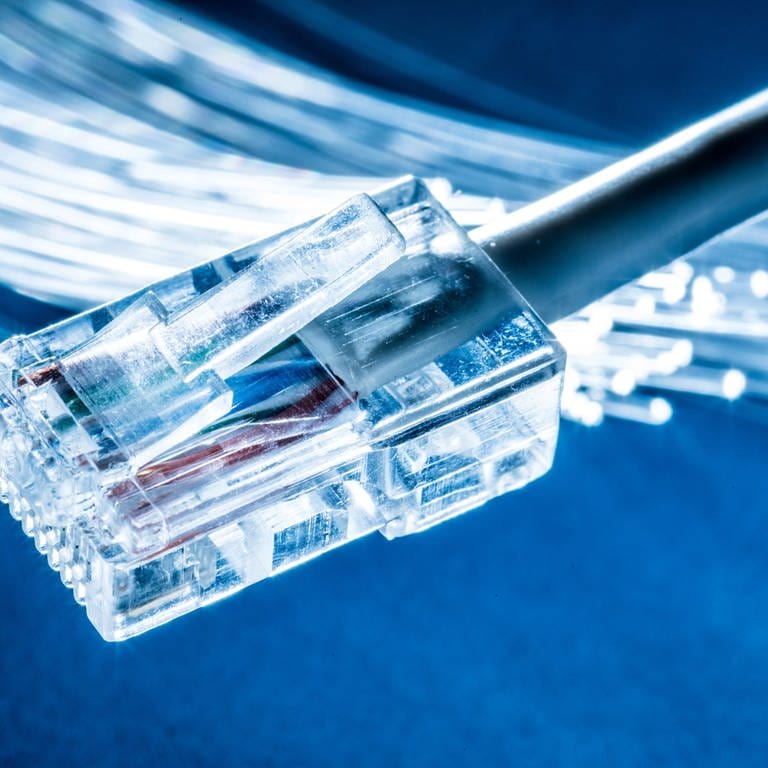 Glasfaserm, davor ein LAN-Kabel. Glasfaservertrag an der Haustür: Verbraucher beschweren sich über Vertriebsmethoden. (Foto: Adobe Stock, Adobe Stock/ volff)