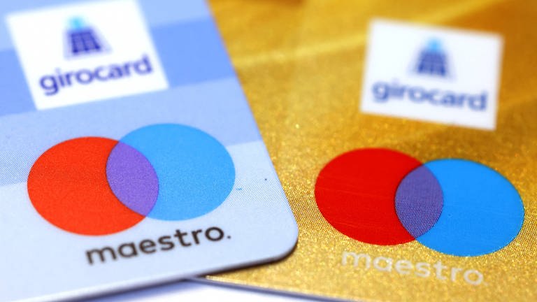 Zwei Bankkarten mit den Maestro- und Girocard-Logos.