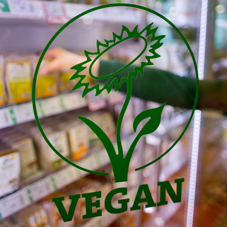  Das Wort "Vegan" ist auf der Glastür eines Kühlregals mit veganen Produkten in einem Biosupermarkt zu lesen. Ersatprodukte für Fisch oder Visch gibt es immer mehr. (Foto: dpa Bildfunk, picture alliance / dpa | Daniel Karmann)