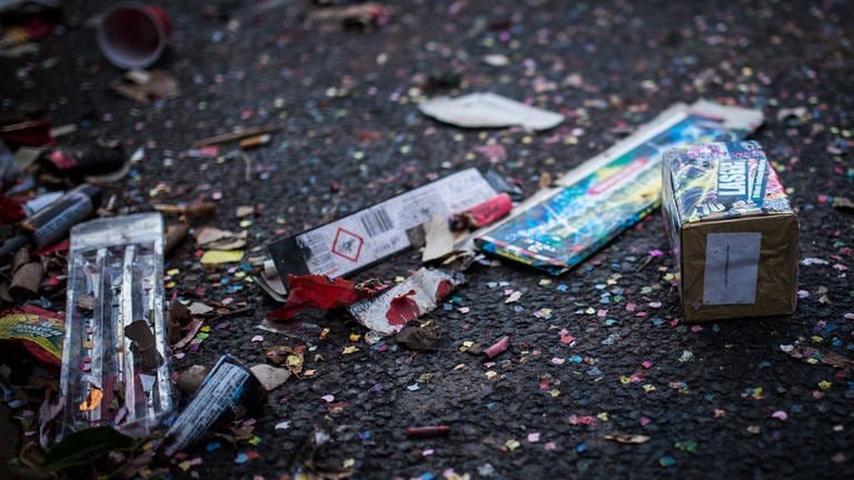 Überreste von Feuerwerkskörpern liegen auf einer Straße. (Foto: dpa Bildfunk, picture alliance / Sophia Kembowski/dpa | Sophia Kembowski)