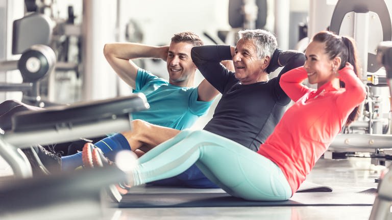 Drei Personen unterschiedlichem Alters machen Sport. Um die Knochen zu stärken und Osteoporose vorzubeugen, spielt Krafttraining eine entscheidende Rolle. Was und wie oft sollte man trainieren, um gesund zu bleiben? 