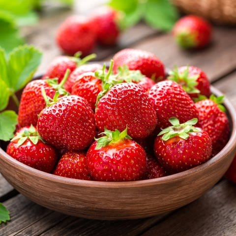 Eine Schale mit Erdbeeren steht auf dem Tisch. Erdbeeren sind gesund und schmecken besonders gut als Kuchen. Aber sie eignen sich auch für herzhafte Rezepte - zum Beispiel im Erdbeer-Spargel-Salat.  