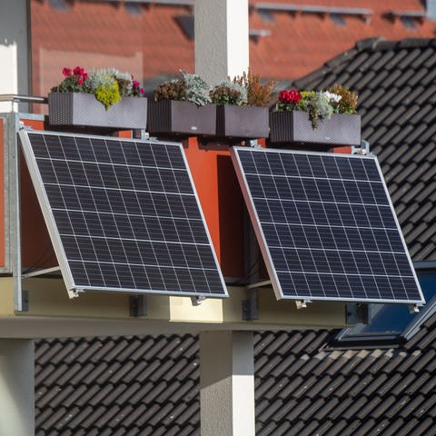 Solarmodule für ein Balkonkraftwerk hängen an einem Balkon. 
