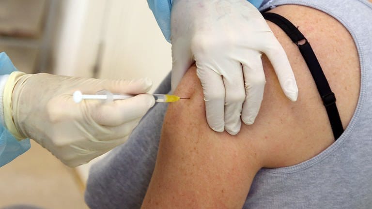 Eine Frau bekommt ihre Booster-Impfung mit dem Comirnaty-Impfstoff des Herstellers BiontechPfizer verabreicht. (Foto: dpa Bildfunk, picture alliance/dpa | Wolfgang Kumm)