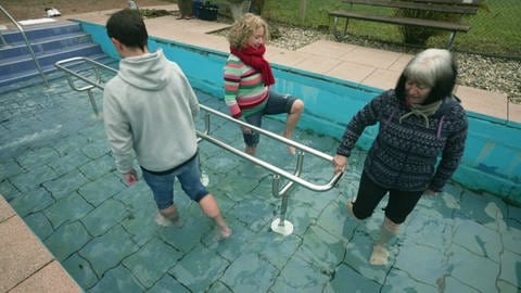 Drei Personen laufen in einem Kneipp-Becken. Nur ihre Füße und Unterschenkel sind im Wasser. Sie betreiben Wassertreten, um ihr Immunsystem zu stärken. (Foto: SWR)
