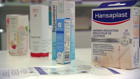 Narbencreme, Narbenöl und Narbenpflaster von verschiedenen Herstellern stehen auf einem Tisch. Sie sollen bei der Reduktion von Narben helfen. (Foto: SWR)
