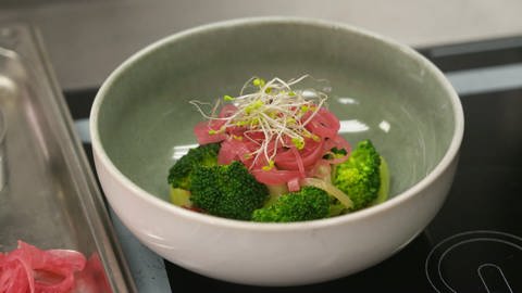 Brokkoli-Röschen mit rosaroten Rettich-Streifen und Sprossen in Schälchen. Rezept für sommerlichen, gesunden, leichten Brokkoli-Salat. (Foto: SWR)