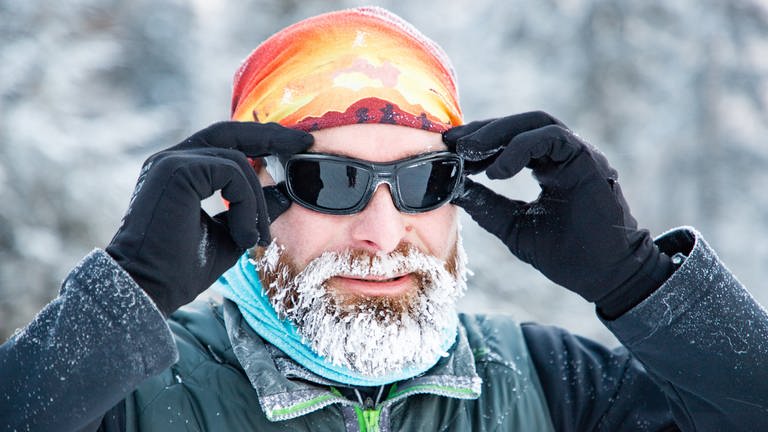Mann mit Mütze, Handschuhen, Sonnenbrille und vereistem Bart. Ist Kälte gut oder schlecht für die Gesundheit? (Foto: Adobe Stock, Adobe Stock | Melinda Nagy)