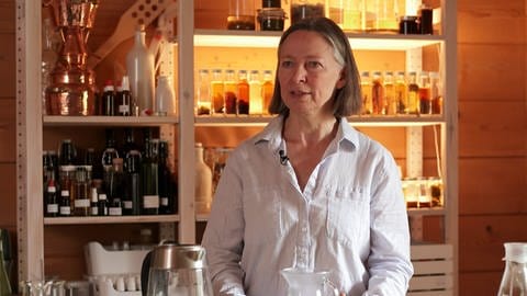 Dr. Karin Buchart, Ernährungswissenschaftlerin Uni Salzburg, steht vor einem Regal, in dem sich verschiedene Arzneien und Heilmittel befinden