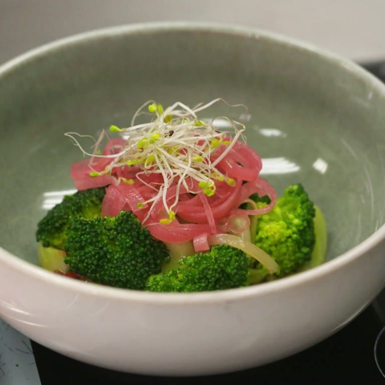 Brokkoli-Röschen mit rosaroten Rettich-Streifen und Sprossen in Schälchen. Rezept für sommerlichen, gesunden, leichten Brokkoli-Salat.