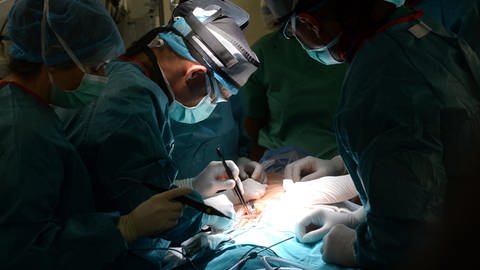 Ärzte operieren einen Menschen am offenen Herzen. (Foto: dpa Bildfunk, Picture Alliance)