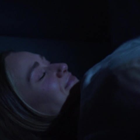 Eine Frau liegt im Bett und schläft