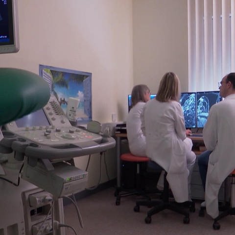 Drei ÄrztInnen sitzen vor PC-Monitor und betrachten Aufnahmen