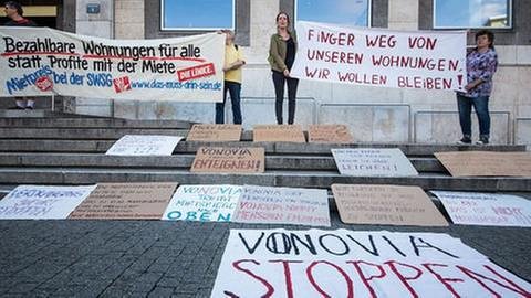 Menschen nehmen vor dem Rathaus an einer Demo gegen Wohnungsnot teil, während im Rathaus die Generaldebatte des Gemeinderates Stuttgart zum Thema Wohnungsnot läuft.