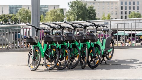 Mehrere grüne E-Bikes stehen aneinander gelehnt am Straßenrand.  (Foto: Colourbox, COLOURBOX54863917)