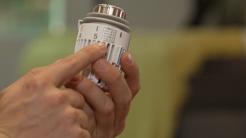 Ein Thermostat wird in einer Hand gehalten, es zeigt die Stufe 5. Wie kann umweltfreundlich geheizt werden? (Foto: SWR)
