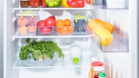 Zu sehen ist ein offener Kühlschrank, gefüllt mit Obst und Gemüse. (Foto: Adobe Stock)