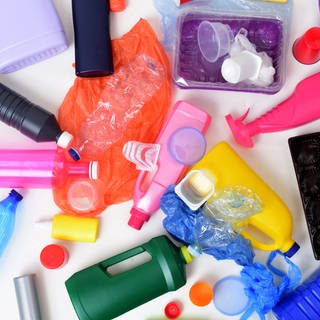 Verschiedene bunte Verpackungen aus Plastik, wie Joghurtbecher Wasserflaschen oder Waschmittel.