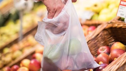 Eine Person verpackt Obst und Gemüse in einem Mehrweg-Netz (Foto: picture-alliance / Reportdienste, dpa Bildfunk, picture alliance/dpa | Marcel Kusch)