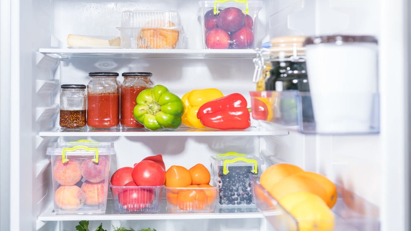 Zu sehen ist ein offener Kühlschrank, gefüllt mit Obst und Gemüse. (Foto: Adobe Stock)