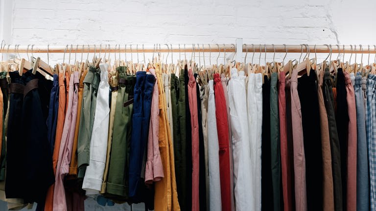 Kleidung an Kleiderstange - Woran erkennt man nachhaltige Kleidung?
