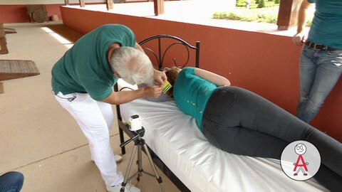 Frau liegt seitlich auf einer Matratze und Orthopäde klebt Punkte auf ihren Rücken. (Foto: SWR, PNG: Matratzen-Check)