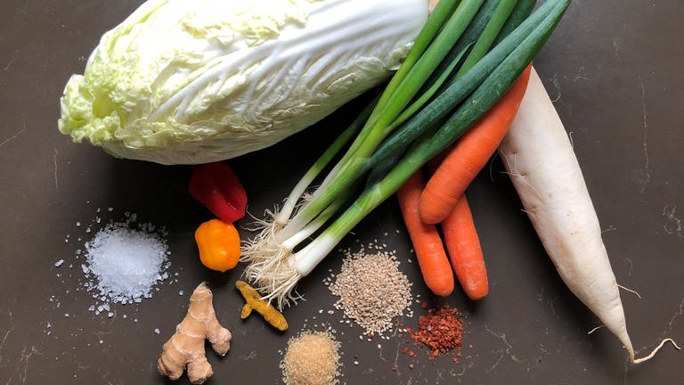 Kimchi-Zutaten liegen vor dem Fermentieren in der Küche: Chinakohl, Rettich, Frühlingszwiebeln, Sesam, Ingwer, Zucker, Salz, Chilis (Foto: SWR, Sabine Schütze)