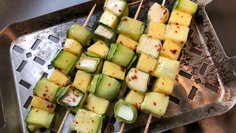 Zucchini-Mango-Spieße mit Chiliflocken liegen auf einer Edelstahlplatte (Foto: SWR, Sabine Schütze)