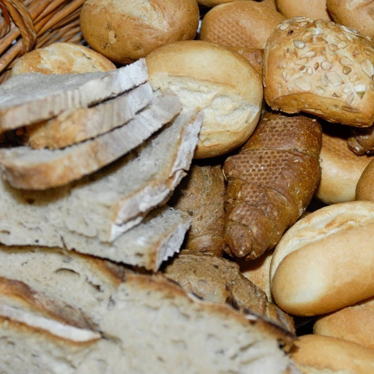 Aufgeschnittenes Brot und verschiedene Brötchen in einem Korb