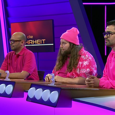 Drei Männer in pinkfarbener Kleidung